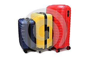 Plastic suitcases of different sizes and colors on wheels are arranged in a row