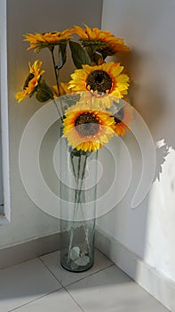 Plastic sunflowers decorating the corner of the house photo