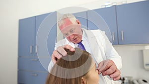 Plastic surgeon consulting a woman patient before nose reshaping procedure at beauty clinic