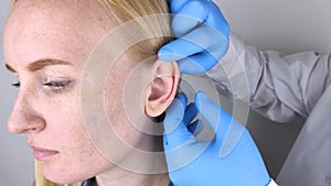 A plastic surgeon examines a patient`s auricle. The doctor sees a tubercle on the curl of the ear.