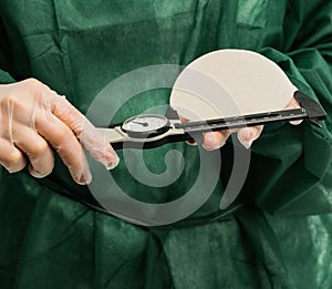 Plastic surgeon hands measuring silicon breast