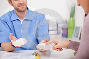 Plastic surgeon showing breast implants to a patient