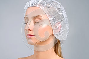 Plastic surgery. Woman with perforation lines on the face. Anti-aging treatment and face lift