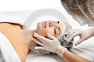 Plastic surgery beauty concept young brunette woman face and doctor hand in glove with syringe