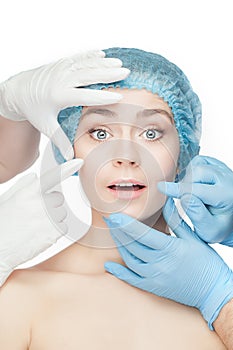 Plastic surgery concept. Doctor hands in gloves touching woman face