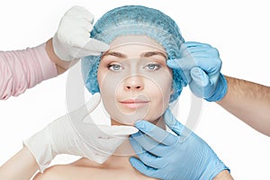 Plastic surgery concept. Doctor hands in gloves touching woman face