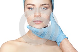 Plastic surgery concept. Doctor hands in gloves touching woman face