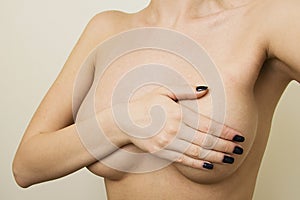 Plastic surgery concept. Woman contols her breast