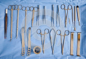 Plastic surgery instruments on blue medical cloth.