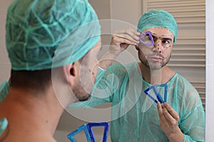 Plastic surgery patient checking his face symmetry