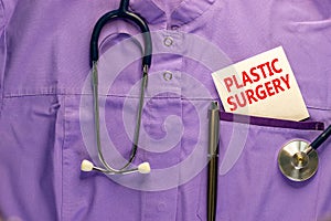 Plastic surgery symbol. Medical uniform, white card with words Plastic surgery, metalic pen and stethoscope. Medical and plastic