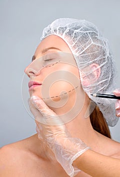 Plastic surgery. Woman with perforation lines on the face. Anti-aging treatment and face lift