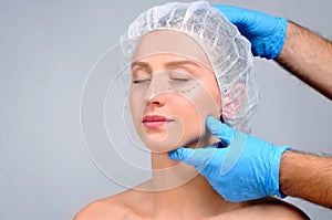 Plastic surgery. Woman with perforation lines on the face. Anti-aging treatment and face lift