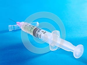 Plastic syringe on blue