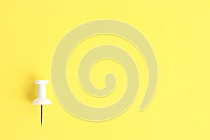 Plastic thumbtack on a yellow background