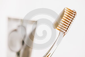 Plastic toothbrush closeup, toothpaste on white blurred background