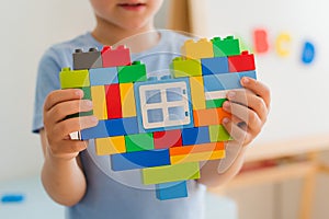 Plastic toy blocks, designer of children`s toys. Bright building blocks in the shape of a heart in children`s hands