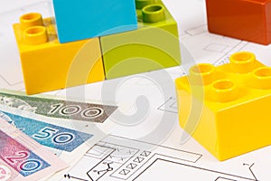 Plastic toy blocks, polish currency money and construction diagrams of house