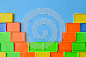Plastic toy building blocks isolated on a blue background