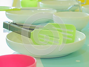 Plastic toy kitchen utensils and tableware toys on a table