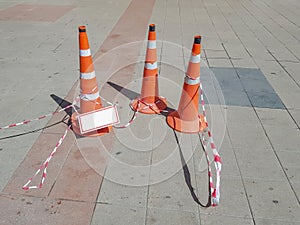 Plastic traffic sign in the shape of a cone on a tile pavement