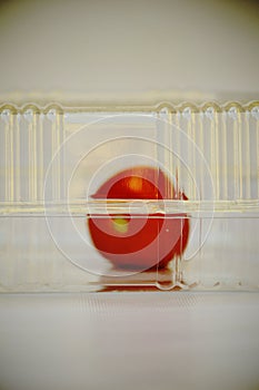 Plastic transparent box with red tomato inside