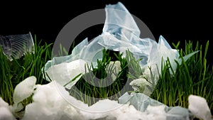 Plastic trash lying on grass among snow, ecology catastrophe, recycling problem