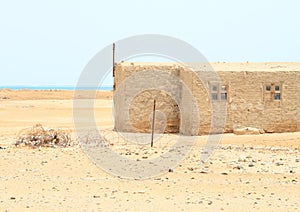 Plastic trash in rusty barbed wire by poor house in Marsa Alam