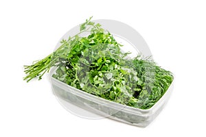 Plastic tray with coriander and dill and bunch of parsley