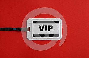 Plastic vip badge on red background, top view