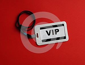 Plastic vip badge on red background, top view