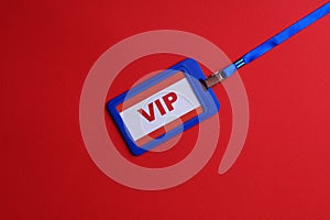 Plastic vip badge on red background, top view