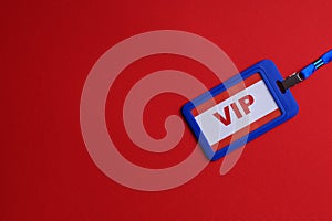 Plastic vip badge on red background, top view. Space for text