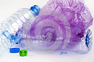 Plastic waste: bottles, polyethylene bags, dice with a question mark.