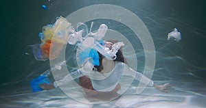 Plastic waste footprint. Young woman throws out garbage bag with various trash floating deep under water slow motion.