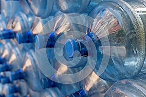 Plastic water bottle background, blue bottle caps, orderly arrangement. Empty bottles for drinking water. Heap of empty plastic dr