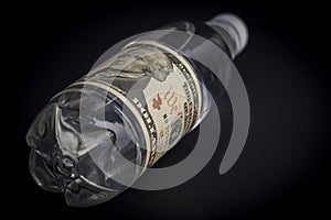 Plastic water bottle with pasted dollar bill