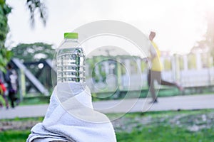 Plastic water bottle and white cloth on desk with running exerci