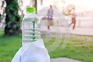 Plastic water bottle and white cloth on desk with running exerci