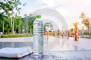 Plastic water bottle and white cloth on desk with running exerci