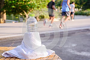 Plastic water bottle and white cloth on desk with running exercise people