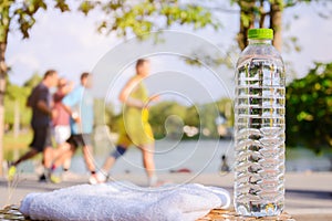 Plastic water bottle and white cloth on desk with running exercise people