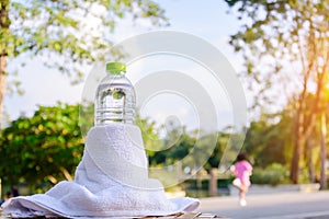 Plastic water bottle and white cloth on desk with running exercise people