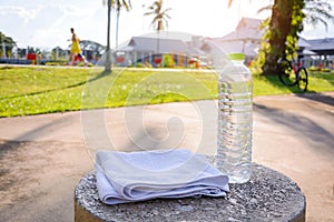 Plastic water bottle and white cloth on desk with running exercise people