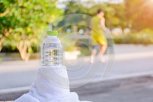 Plastic water bottle and white cloth on desk with running exercise people
