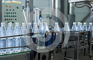 Plastic water bottles on conveyor and water bottling machine industry.