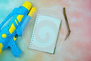 Plastic water gun and empty notepad