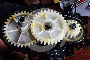 Plastic white gears of the mechanism in yellow grease