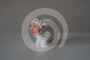 Plastic white lamb on white shelf