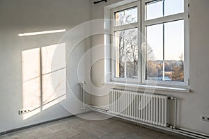 Plastic window and radiator in a light empty room